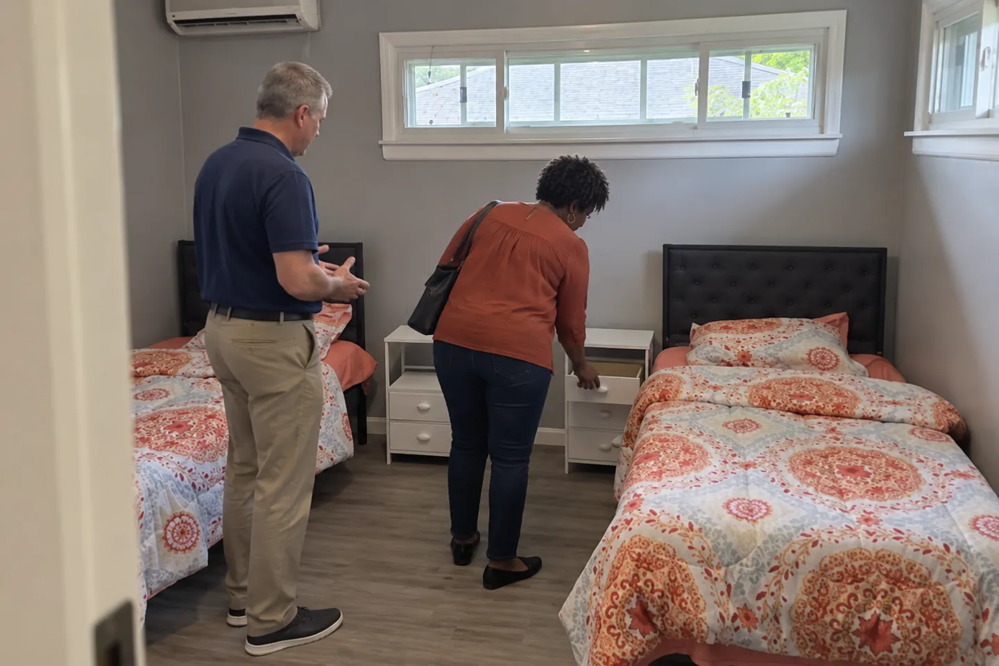 A couple looking at a shared bedroom